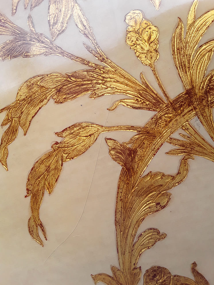Mesa baja de centro lacada en crema con motivos florales dorados | Vista detalle del adorno floral de la mesa